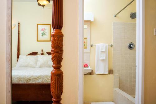 um quarto com uma cama e uma casa de banho com um chuveiro em ZenBreak Golden View #115 em Saint James
