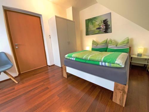 a small bedroom with a bed with green sheets at Jacky & Daniel's Apartments Top 2 in Sankt Pölten
