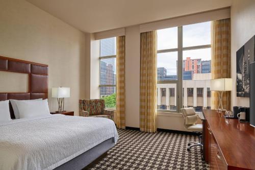 a hotel room with a bed and a desk and window at Courtyard by Marriott Denver Downtown in Denver