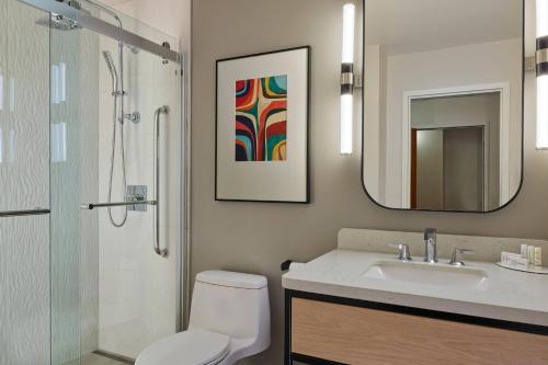 a bathroom with a toilet and a sink and a mirror at Courtyard by Marriott Denver Downtown in Denver