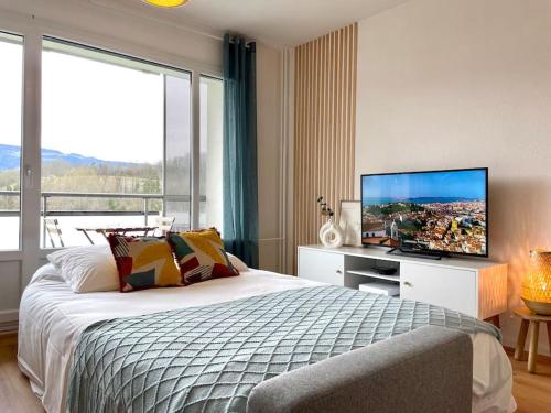 ein Schlafzimmer mit einem Bett und einem großen Fenster in der Unterkunft Appartement - Lit Queen Size - Proximité Genève in Saint-Julien-en-Genevois
