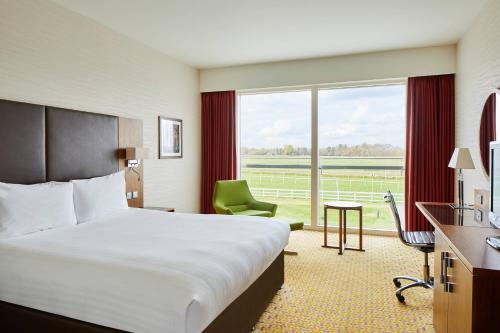 a hotel room with a bed and a large window at Lingfield Park Marriott Hotel & Country Club in Lingfield