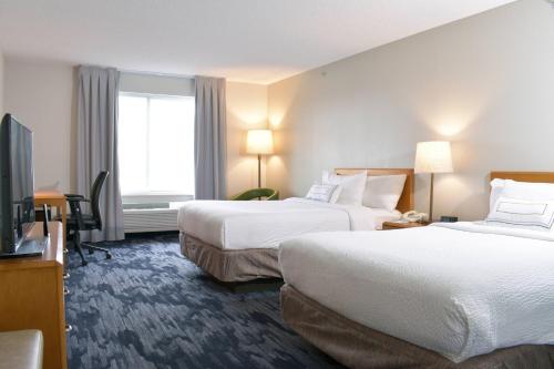 um quarto de hotel com duas camas e uma televisão de ecrã plano em Fairfield Inn & Suites Indianapolis East em Indianápolis