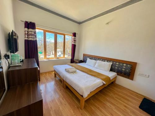 a bedroom with a bed and a television in it at Zeejeed palace in Leh