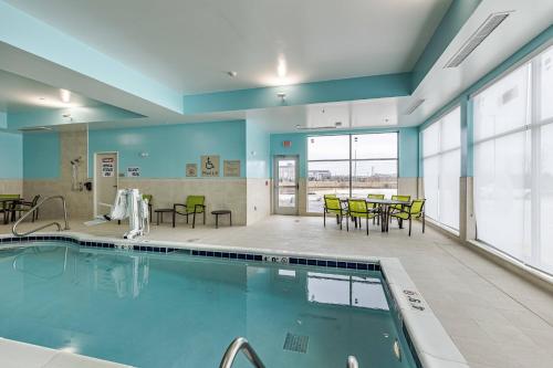 una piscina en un edificio con mesas y sillas en SpringHill Suites by Marriott Fort Wayne North, en Sunnybrook Acres