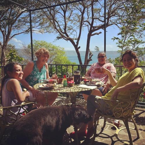a group of people sitting at a table with a dog at Casa Única in La Laguna