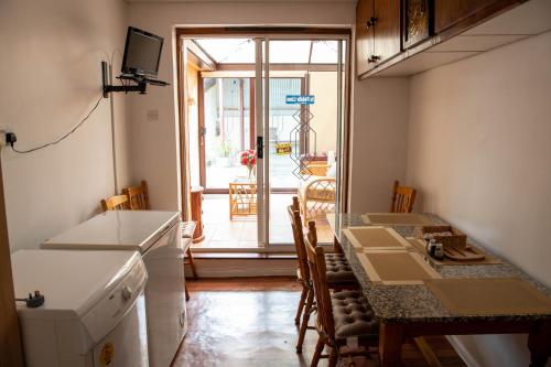 een keuken en eetkamer met een tafel en een raam bij Sheila's Cottage Ballyheigue in Ballyheigue