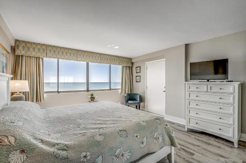 ein Schlafzimmer mit einem großen Bett und einem TV in der Unterkunft Carolina Dunes - 403 in Myrtle Beach