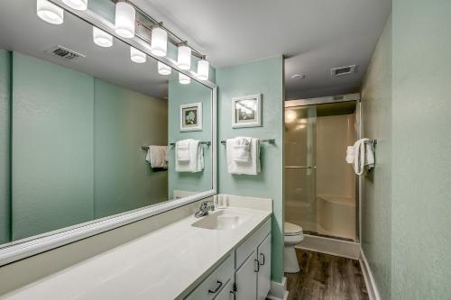 ein Bad mit einem Waschbecken und einem Spiegel in der Unterkunft Carolina Dunes - 403 in Myrtle Beach