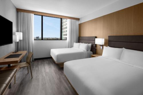 a hotel room with two beds and a desk and a television at AC Hotel By Marriott Miami Brickell in Miami