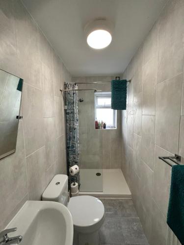 West Kirby home for Open golf at Hoylake في ويست كيربي: حمام به مرحاض أبيض ومغسلة