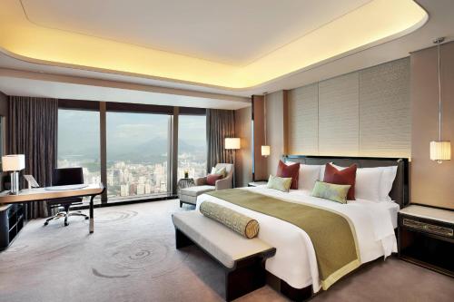 um quarto grande com uma cama grande e uma secretária em The St. Regis Shenzhen em Shenzhen