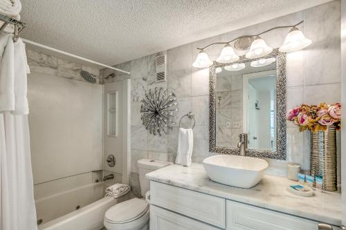 a bathroom with a sink and a toilet and a mirror at Forest Dunes Penthouse 1801 in Myrtle Beach