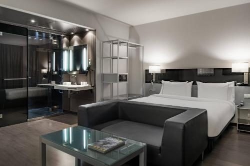 a hotel room with a bed and a couch at AC Hotel Atocha by Marriott in Madrid