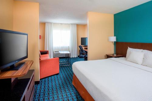 um quarto de hotel com uma cama e uma televisão de ecrã plano em Fairfield Inn & Suites Peru em Peru