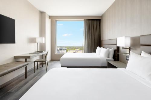 um quarto de hotel com duas camas e uma secretária em AC Hotel by Marriott Bethesda Downtown em Bethesda