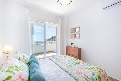 ビリャホヨサにあるCala Palmera 10-C Apartment Playa La Cala Beachの海の見えるベッドのある寝室