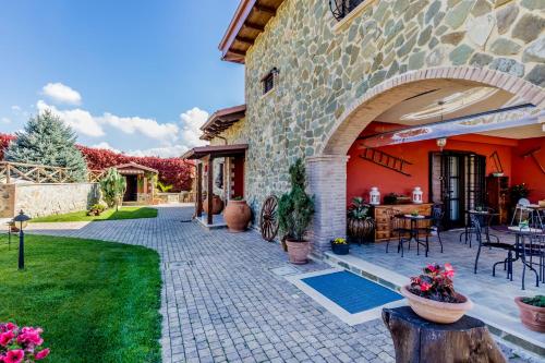 a stone house with a patio and a yard at B&B A casa di Giulia in Guidonia