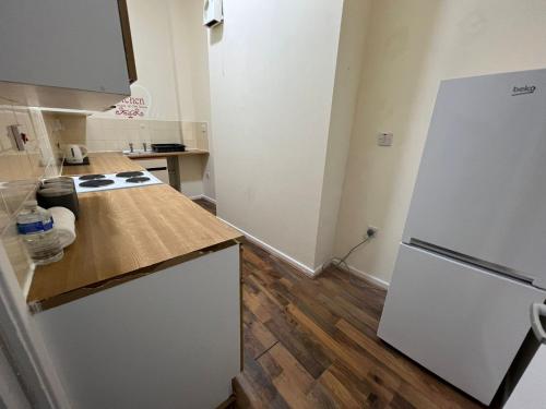 a kitchen with a white refrigerator and a wooden floor at ☆ Property Buzzer Serviced Apartments ☆ 1 Bed Flat Birmingham City Centre - China Town ☆ Very close to Bull Ring, Grand Central + Mailbox ☆ in Birmingham