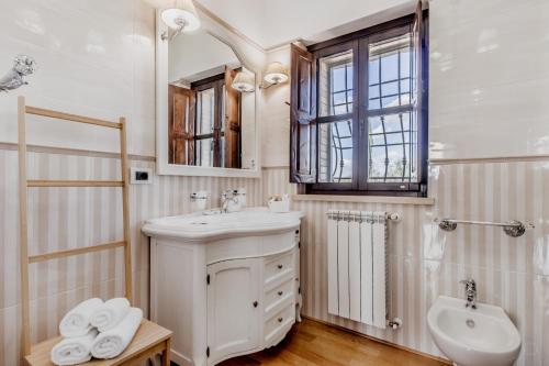 La salle de bains blanche est pourvue d'un lavabo et de toilettes. dans l'établissement B&B A casa di Giulia, à Guidonia