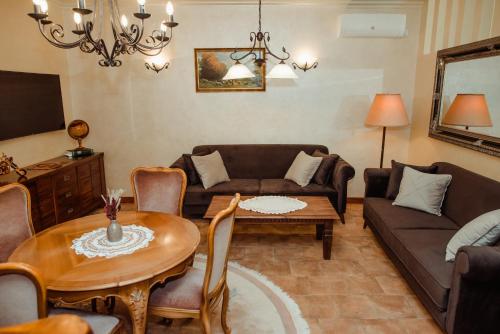 een woonkamer met een bank en een tafel bij Aquapalic Resort in Palić