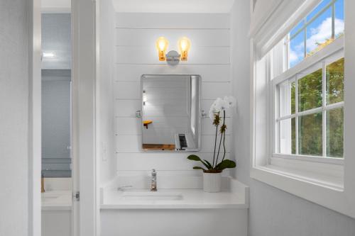 Baño blanco con lavabo y espejo en Nantucket Inn, en Nantucket