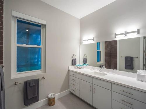 uma casa de banho branca com 2 lavatórios e uma janela em Luxury Cayman Villas em Driftwood Village