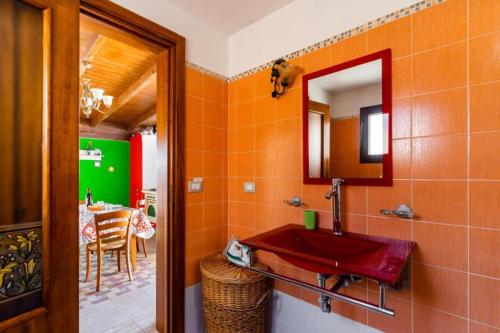 a bathroom with a red sink and a mirror at ATTICO SUL MARE in Gallipoli