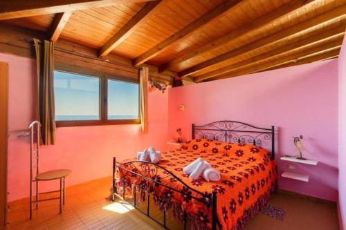a bedroom with a bed in a room with pink walls at ATTICO SUL MARE in Gallipoli