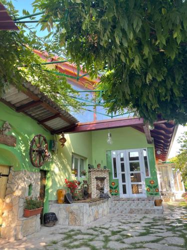 a green house with a fireplace in front of it at Pensiunea Doina și Ion in Mileştii Mici