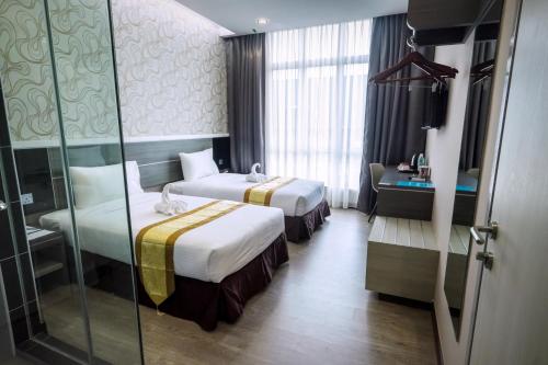 Кровать или кровати в номере Indra Hotel Ipoh