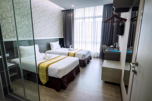 Postel nebo postele na pokoji v ubytování Indra Hotel Ipoh