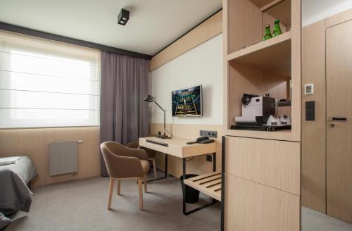 a hotel room with a desk and a bed at Ilonn Hotel in Poznań
