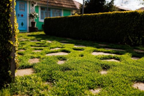 a garden with grass and stones in front of a house at Pensiunea Doina și Ion in Mileştii Mici
