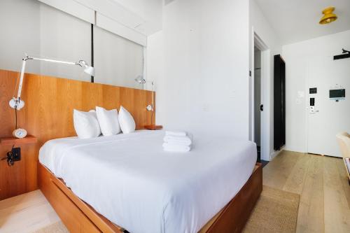 a bedroom with a large bed with white sheets at Placemakr Wall Street in New York