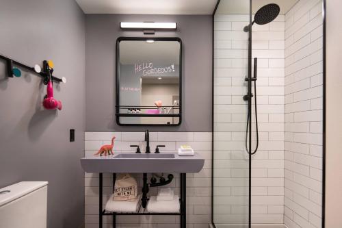 een badkamer met een wastafel en een spiegel bij Moxy Portland Downtown in Portland