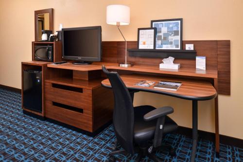 a desk with a television and a chair in a hotel room at Fairfield Inn & Suites Louisville North in Jeffersonville