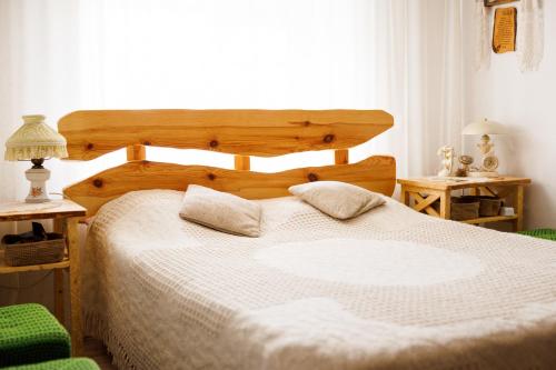a bedroom with a wooden bed with two pillows on it at Pensiunea Doina și Ion in Mileştii Mici