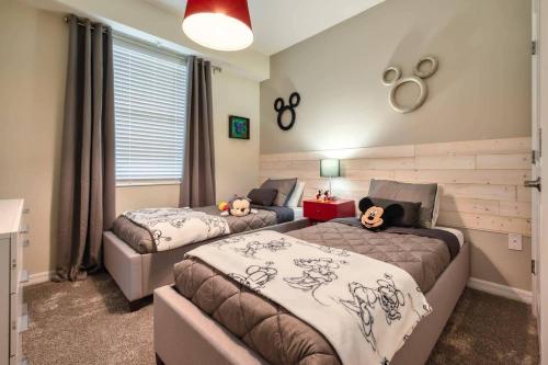 - une chambre avec 2 lits avec des animaux rembourrés dans l'établissement Modern 2 Bedrooms 2 Baths Condo - 5 miles to Disney 206, à Kissimmee