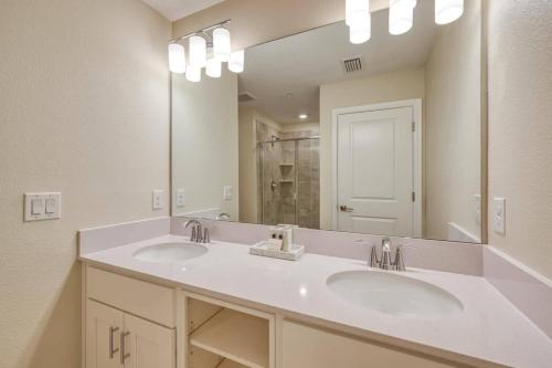 une salle de bain avec deux lavabos et un grand miroir dans l'établissement Modern 2 Bedrooms 2 Baths Condo - 5 miles to Disney 206, à Kissimmee