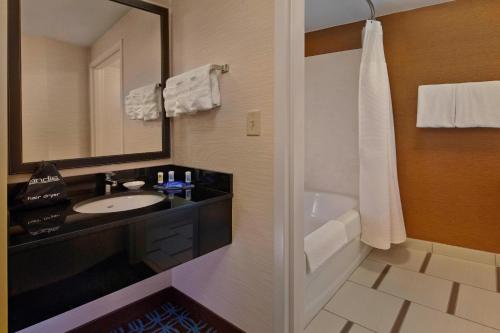 W łazience znajduje się umywalka, wanna i lustro. w obiekcie Fairfield Inn & Suites Boca Raton w mieście Boca Raton