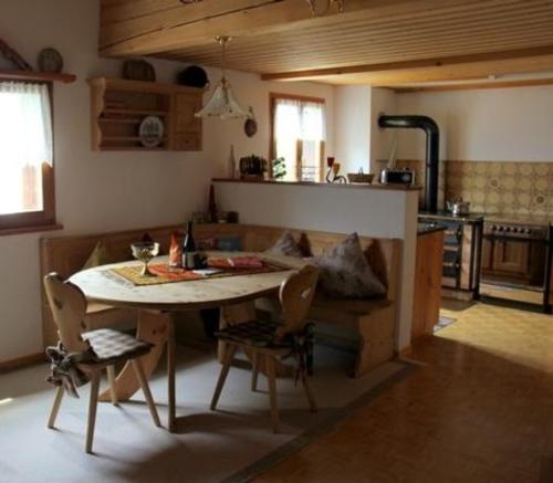 - une cuisine et une salle à manger avec une table et un canapé dans l'établissement Alpe Monte Massella, à Poschiavo
