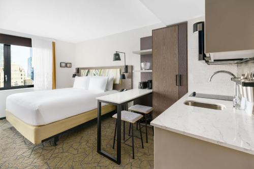 a hotel room with a bed and a kitchen at TownePlace Suites by Marriott New York Manhattan/Chelsea in New York