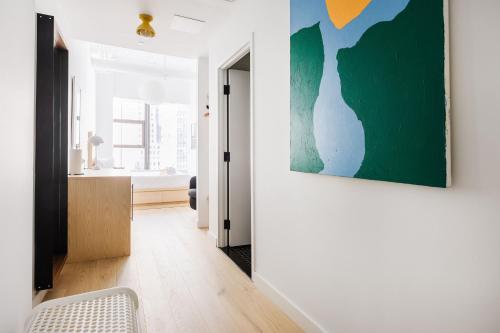 a living room with a painting on the wall at Placemakr Wall Street in New York