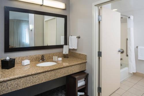 a bathroom with a sink and a mirror at Courtyard by Marriott Miami West/FL Turnpike in Miami