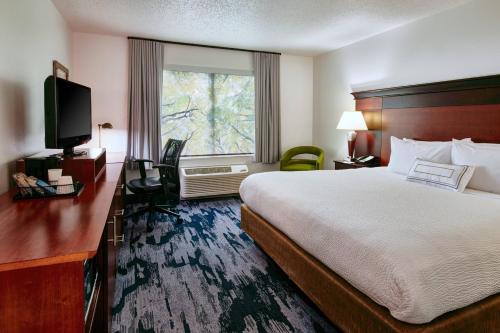 a hotel room with a bed and a window at Fairfield Inn & Suites Detroit Livonia in Livonia