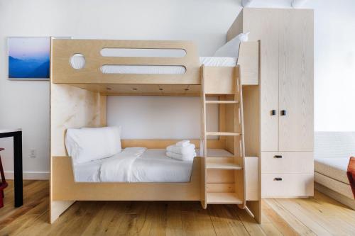 a small bedroom with a bunk bed with a ladder at Placemakr Wall Street in New York
