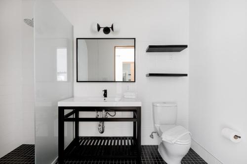 a white bathroom with a sink and a toilet at Placemakr Wall Street in New York