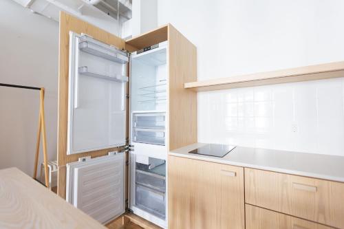 a kitchen with wooden cabinets and a refrigerator at Placemakr Wall Street in New York