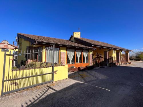 ein gelbes Gebäude mit einem Zaun davor in der Unterkunft Hotel e B&B Il Mulino in Vaiano